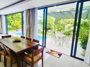 a dining room with a table and a large window at Danang Villas Complex in Danang