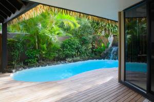 a swimming pool in the backyard of a house at Reflections On Rarotonga in Rarotonga