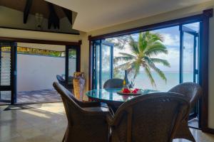 a dining room with a table and chairs and a view of the ocean at Reflections On Rarotonga in Rarotonga