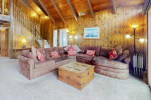 a living room with a couch and a wooden wall at Rocky Pines in Twin Peaks