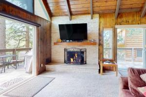 a living room with a fireplace and a tv at Rocky Pines in Twin Peaks