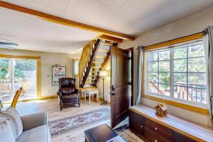 a living room with a spiral staircase and a chair at Heliotrope Hideaway in Lake Arrowhead