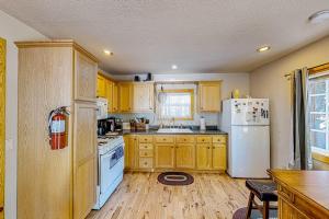 a kitchen with wooden cabinets and a white refrigerator at Heliotrope Hideaway in Lake Arrowhead +22 photos