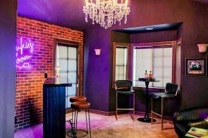 a bar with purple walls and stools in a room at The Chateau in Lake Arrowhead