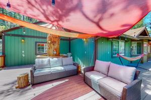 a patio with a couch and a hammock on a deck at Creekside Cabin in Crestline