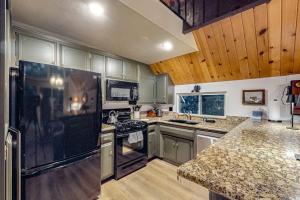 eine große Küche mit Edelstahlgeräten und Holzdecken in der Unterkunft Pinecrest Paradise in Crestline + 16 Fotos