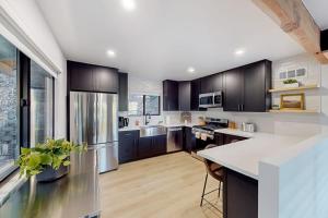 a kitchen with black cabinets and a white counter top at The Snow White in Lake Arrowhead
