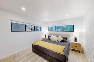 a bedroom with a large bed and three windows at The Snow White in Lake Arrowhead +8 photos