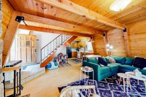 a living room with a green couch and wooden ceilings at Hidden Wonder in Crestline