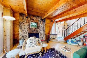 a living room with a stone fireplace in a house at Hidden Wonder in Crestline