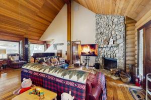 a living room with a couch and a stone fireplace at Sugar Pine Retreat in Twin Peaks