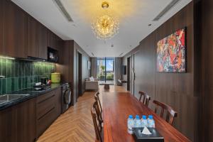 a kitchen with a long wooden table in a room at MAIA Boutique Hotel Da Nang in Danang