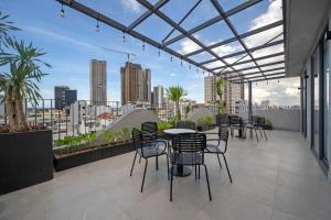 a balcony with tables and chairs and a view of the city at MAIA Boutique Hotel Da Nang in Danang