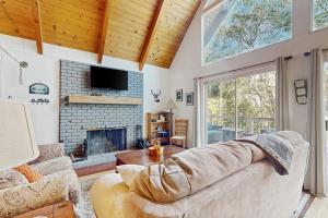 a living room with a couch and a fireplace at Cedar Glen Hideaway in Lake Arrowhead