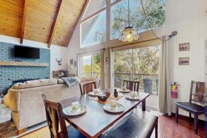 a dining room with a table and a couch at Cedar Glen Hideaway in Lake Arrowhead