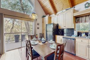 a kitchen with a wooden table and a large window at Cedar Glen Hideaway in Lake Arrowhead +17 photos