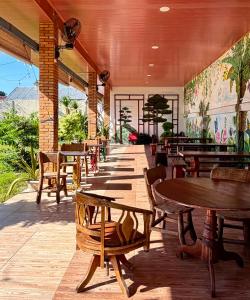 a restaurant with wooden tables and chairs and tables at Joyful Hotel in Tanjungpandan