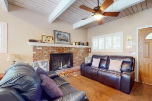 a living room with a leather couch and a fireplace at Dancing Bear Chalet in Lake Arrowhead