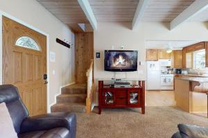 a living room with a television on a table and a kitchen at Dancing Bear Chalet in Lake Arrowhead