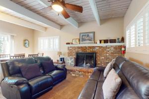 a living room with a leather couch and a fireplace at Dancing Bear Chalet in Lake Arrowhead