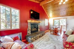 a living room with a fireplace and red walls at Sky High Cabin in Crestline