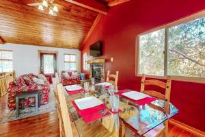 a living room with red walls and a table and chairs at Sky High Cabin in Crestline +22 photos