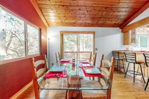 a dining room with a glass table and chairs at Sky High Cabin in Crestline