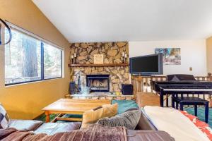 a living room with a fireplace and a piano at Morrison Manor in Lake Arrowhead