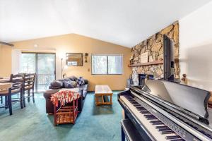 a living room with a piano and a stone wall at Morrison Manor in Lake Arrowhead