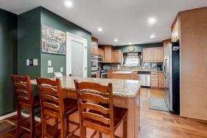 a kitchen with green walls and a counter with chairs at Running Springs R-n-R in Running Springs