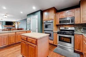 a kitchen with wooden cabinets and stainless steel appliances at Running Springs R-n-R in Running Springs +20 photos