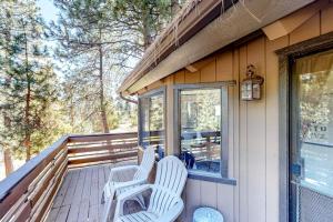 two white chairs sitting on the porch of a house at Grey Stone Fire in Running Springs