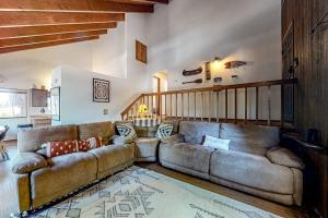 a living room with a large couch and a staircase at Grey Stone Fire in Running Springs