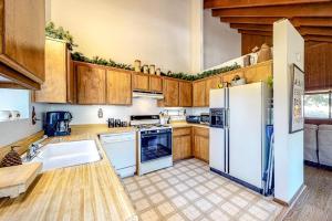 a kitchen with white appliances and wooden cabinets at Grey Stone Fire in Running Springs +10 photos