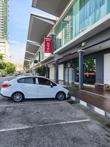 a white car parked in front of a building at Hotel Dream Nur Kota Syahbandar in Malacca