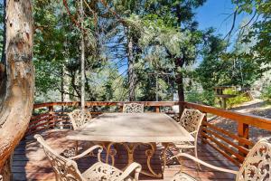 a table and chairs on a wooden deck at Retro Cabin in Lake Arrowhead