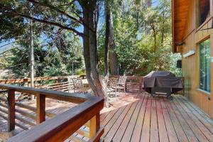 a wooden deck with a table and chairs on a house at Retro Cabin in Lake Arrowhead