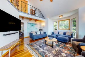 a living room with blue couches and a flat screen tv at Million Dollar Mountain View in Crestline