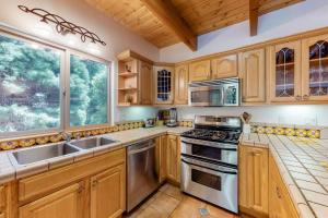 a kitchen with wooden cabinets and stainless steel appliances at Million Dollar Mountain View in Crestline +23 photos