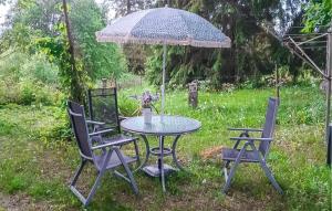 a patio table with two chairs and an umbrella at Amazing Home In Sävsjö With Kitchen in Sävsjö