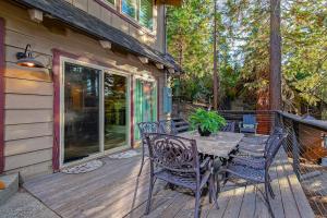 a patio with a table and chairs on a deck at Serene Cabin in Lake Arrowhead