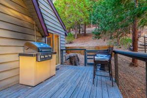 a grill and a chair sitting on a deck at Serene Cabin in Lake Arrowhead