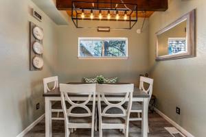 a dining room with a table and white chairs at Blue Bird Beauty in Running Springs