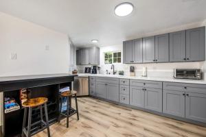 a kitchen with gray cabinets and wooden floors at Red Cottage Charmer in Lake Arrowhead +18 photos