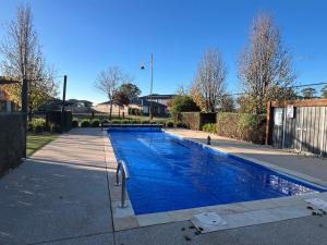a swimming pool with blue water in a driveway at PONZ Lake Retreat - Nagambie in Nagambie