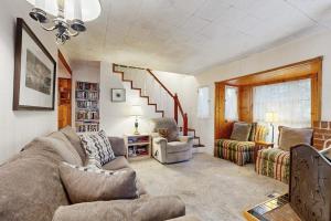 a living room with a couch and chairs and a staircase at The Cottage in Lake Arrowhead
