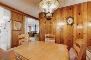 a dining room with a table and a clock on the wall at The Cottage in Lake Arrowhead +23 photos