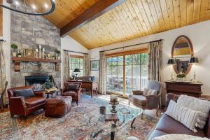 a living room with a stone fireplace and leather furniture at Treetop Cottage in Running Springs