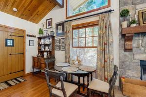 a dining room with a table and a window at Treetop Cottage in Running Springs +10 photos