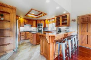 a kitchen with wooden cabinets and a large island with bar stools at Deer Mountain in Lake Arrowhead